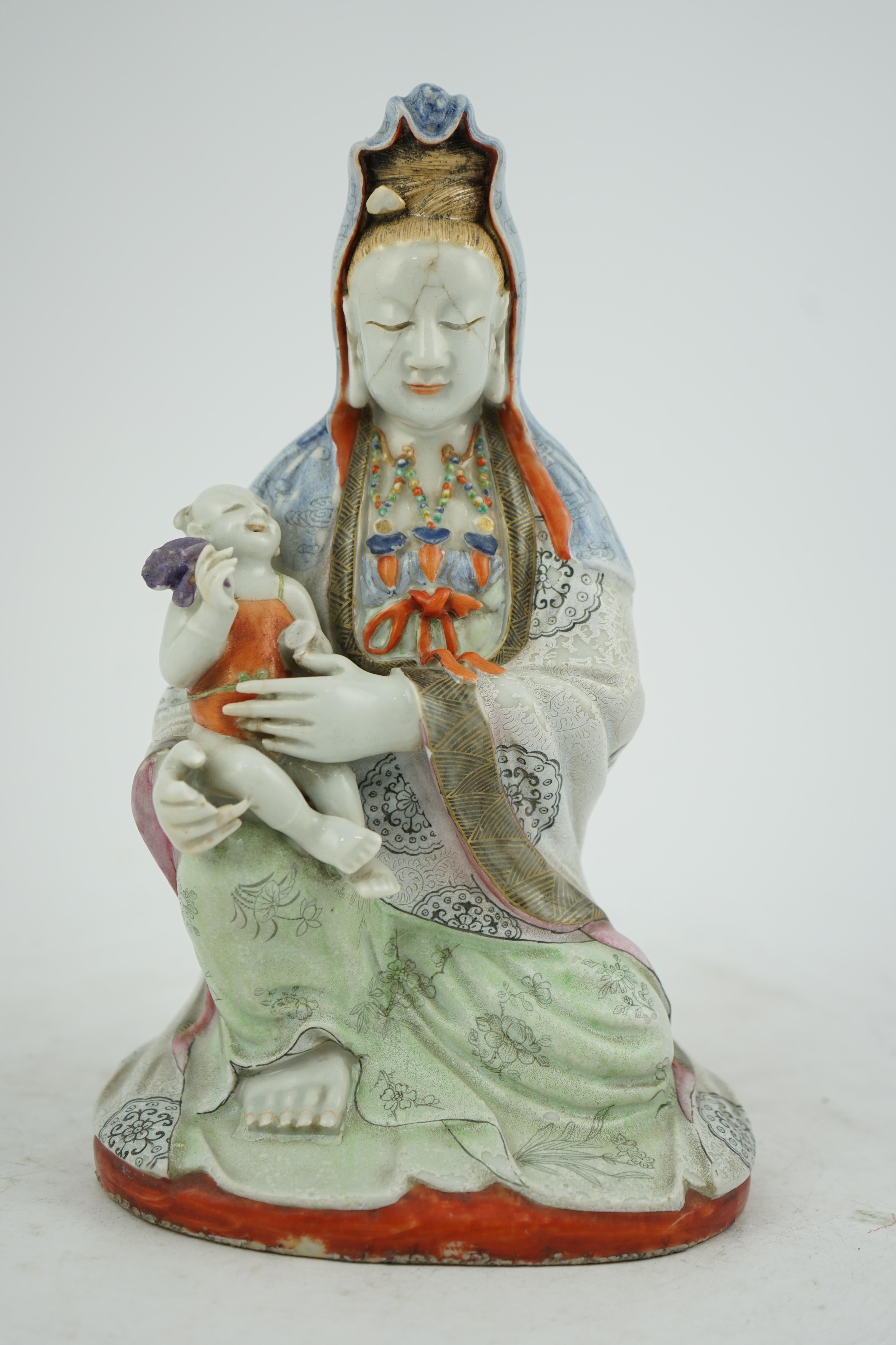 A Chinese enamelled porcelain group of Guanyin holding a child, Qianlong period